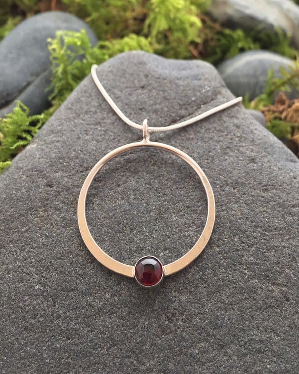 Saucy Jewelry circular pendant with red gemstone